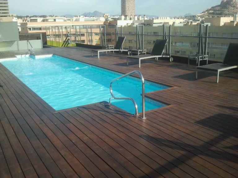 Suelo de madera de teca de una piscina tras ser acuchillado y tratado